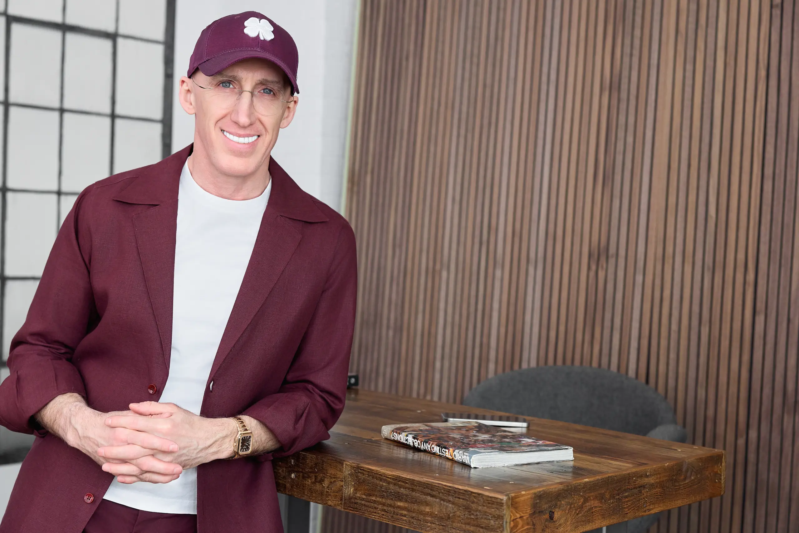 Professional portrait of Uri Poliavich in a stylish burgundy outfit indoors